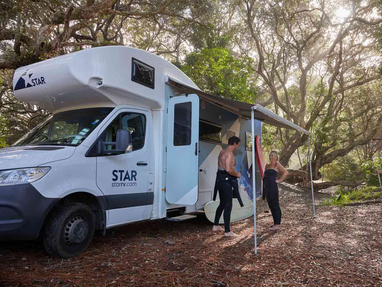Couple putting on wetsuits outside Star RV motorhome